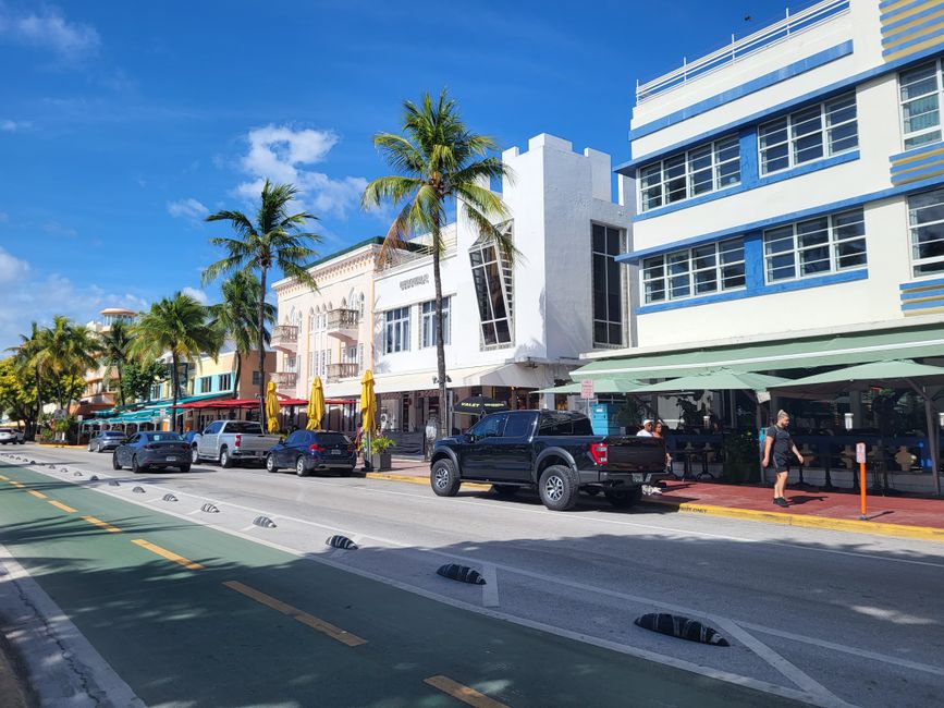 Vibrant street scene in Miami's South Beach showcasing iconic Art Deco buildings and palm trees.